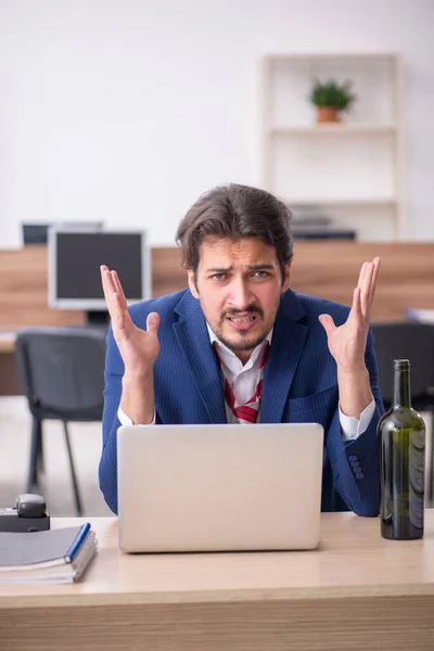 Joven adicto al alcohol empleado masculino que trabaja en la oficina — Foto de Stock