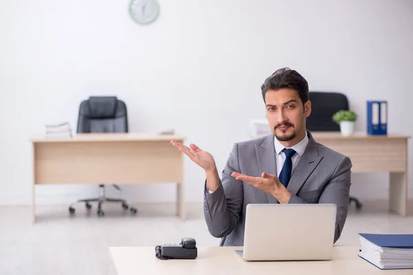 Jonge mannelijke werknemer werkzaam in het kantoor — Stockfoto