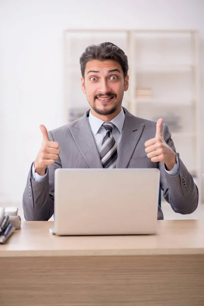 Jovem funcionário masculino infeliz com excesso de trabalho no escritório — Fotografia de Stock