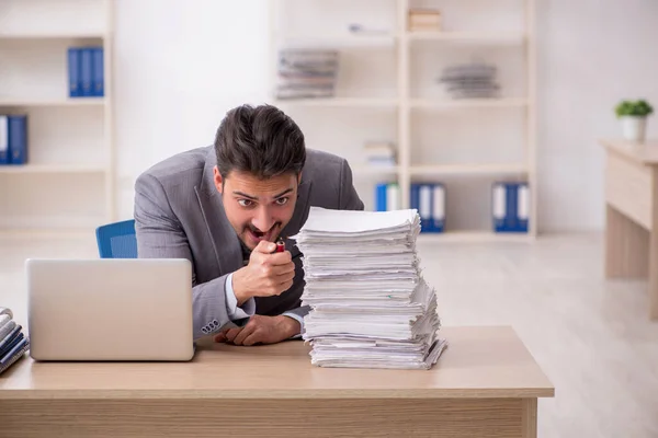 Jovem funcionário masculino infeliz com excesso de trabalho no escritório — Fotografia de Stock