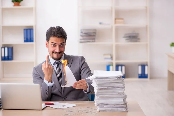 Young male employee unhappy with excessive work in the office — Stock Photo, Image