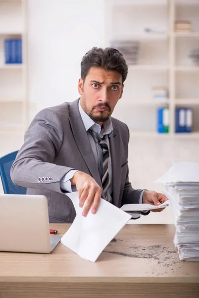 Jovem funcionário masculino infeliz com excesso de trabalho no escritório — Fotografia de Stock