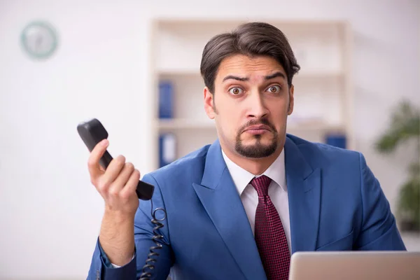 Jovem trabalhador masculino sentado no local de trabalho — Fotografia de Stock