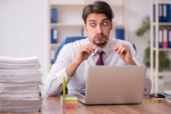 Junge männliche Mitarbeiter und zu viel Arbeit im Büro — Stockfoto