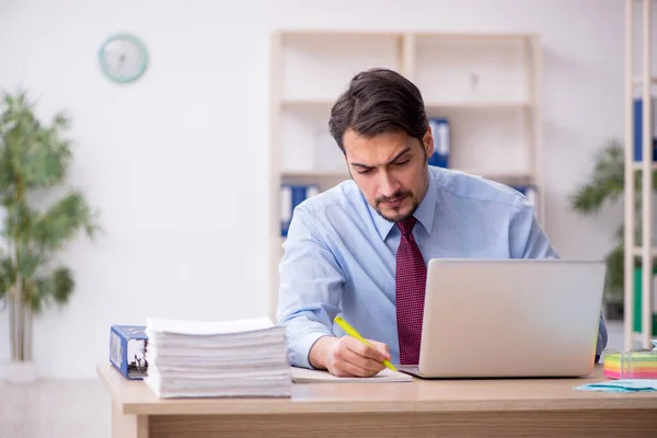 Jeune employé masculin et trop de travail au bureau — Photo