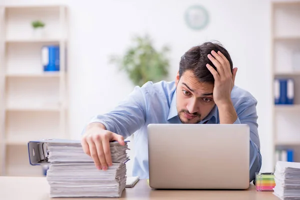 Junge männliche Mitarbeiter und zu viel Arbeit im Büro — Stockfoto