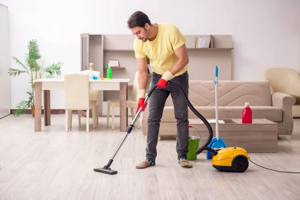 Jovem empreiteiro limpando a casa — Fotografia de Stock