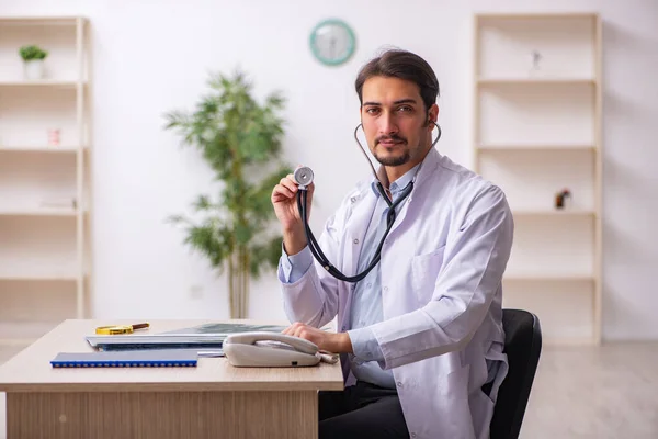 Ung manlig läkare som arbetar på kliniken — Stockfoto