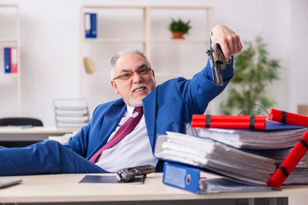 Starý muž zaměstnanec s dynamitem v kanceláři — Stock fotografie