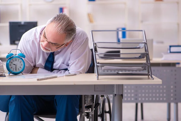 Velho empregado masculino em cadeira de rodas no conceito de gerenciamento de tempo — Fotografia de Stock