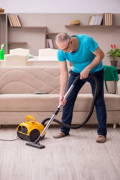 Old man cleaning the house — Stock Photo, Image