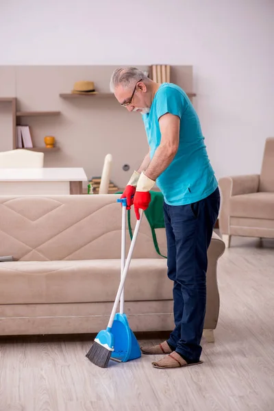 Old man cleaning the house — Stock Photo, Image