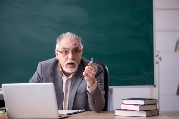 Oude mannelijke leraar voor schoolbord — Stockfoto