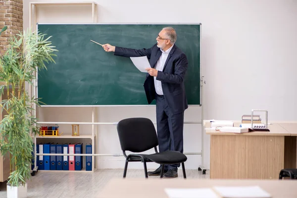 Oude mannelijke leraar voor schoolbord — Stockfoto