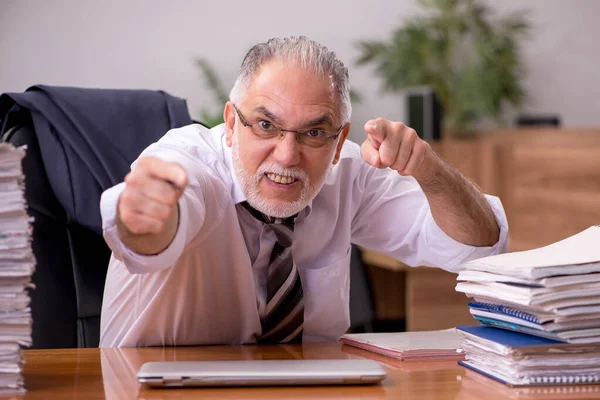 Velho empregado masculino e muito trabalho no escritório — Fotografia de Stock