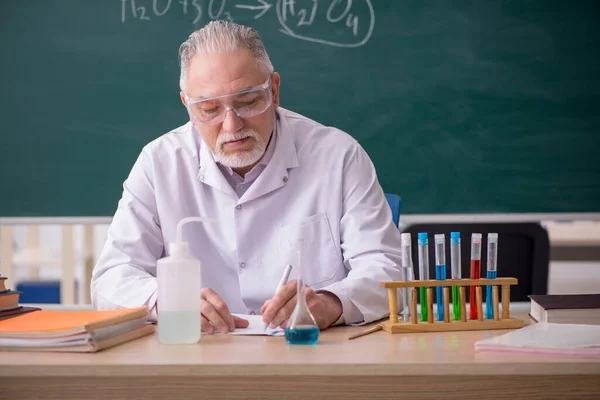 Starý muž chemik učitel ve třídě — Stock fotografie
