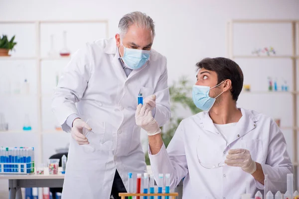 Dois químicos do sexo masculino no conceito de síntese de drogas no laboratório — Fotografia de Stock