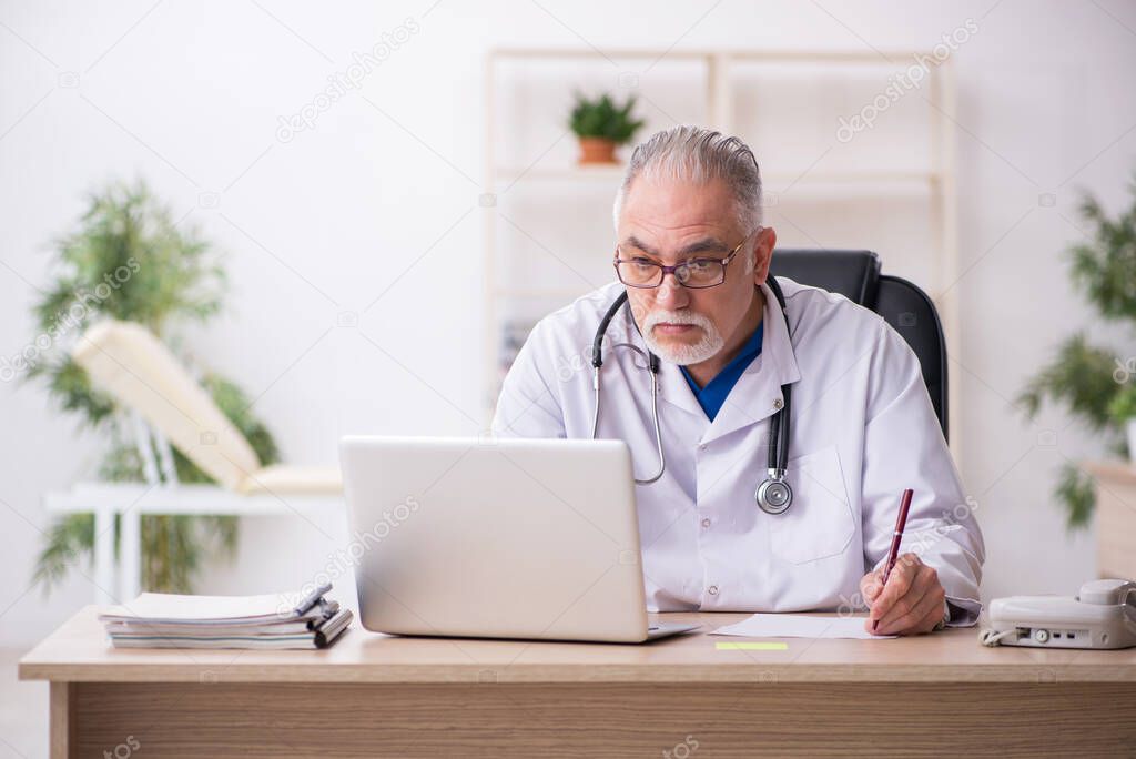 Old male doctor working in the clinic