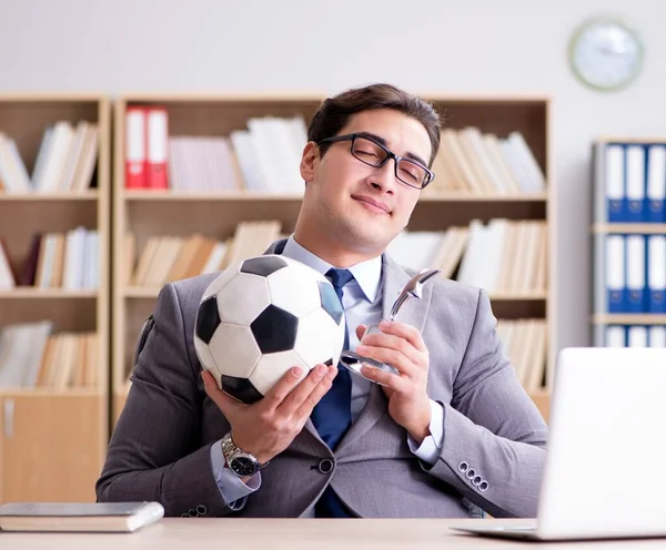 Empresário com bola de futebol no escritório — Fotografia de Stock