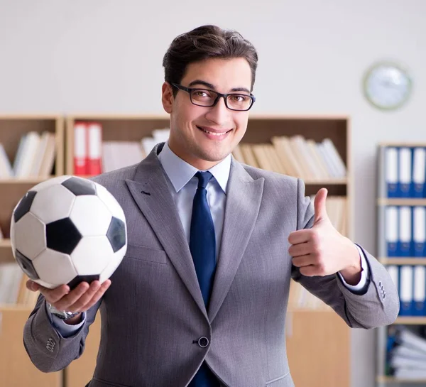 Empresário com bola de futebol no escritório — Fotografia de Stock