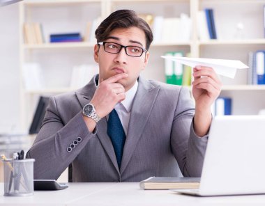 Ofisinde kağıt uçak olan bir iş adamı.