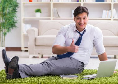 İş adamı ofiste yerde oturuyor.