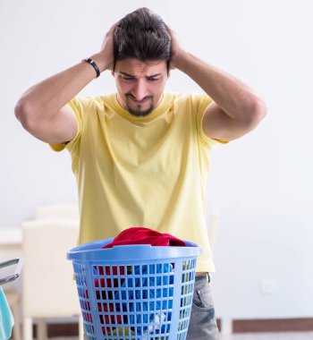 Yakışıklı koca evde çamaşır yıkıyor.