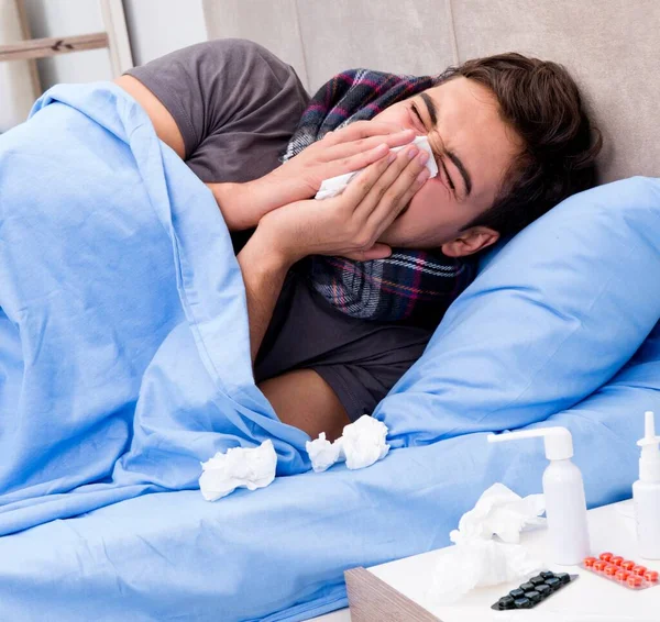 Zieke man in bed die medicijnen en drugs gebruikt — Stockfoto