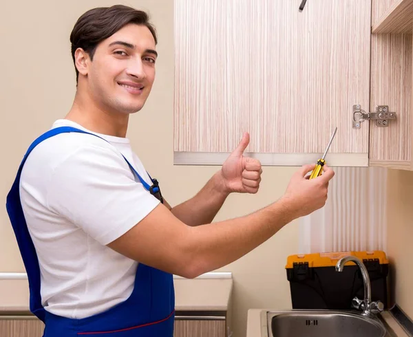 Young man assembling kitchen furniture — Stock Photo, Image