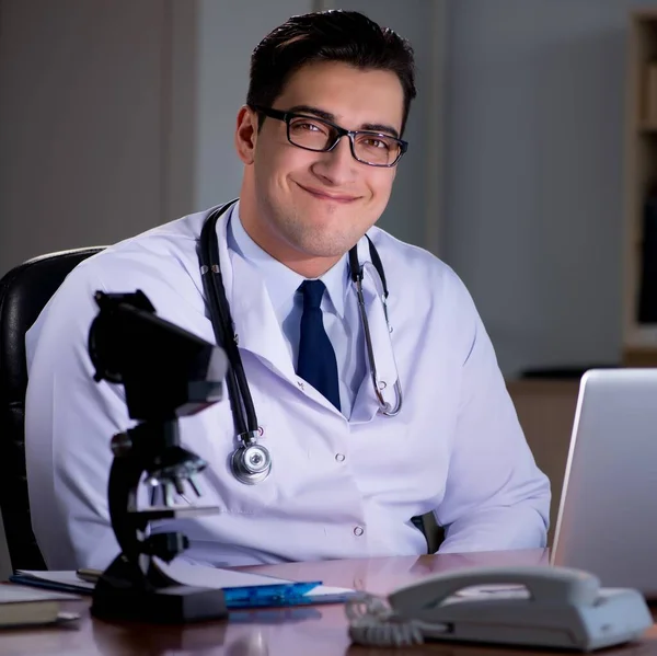 Junger Arzt arbeitet spät im Büro — Stockfoto