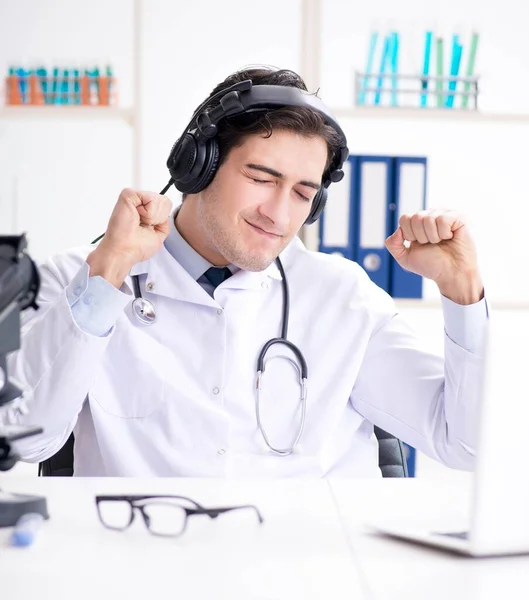 Feliz médico emocionado escuchando música durante la pausa del almuerzo en ho — Foto de Stock