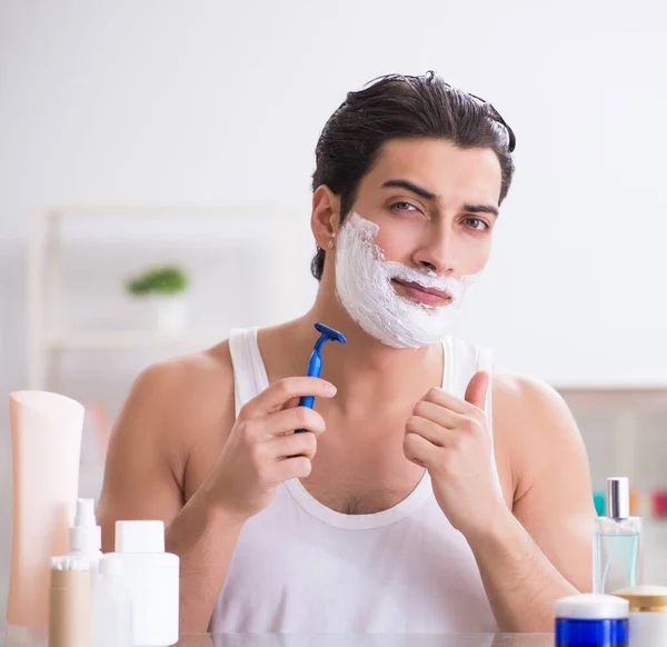 Fiatal jóképű férfi borotválkozik korán reggel otthon. — Stock Fotó