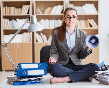 İş kadını ofiste meditasyon yapıyor.