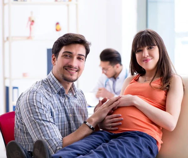 Terhes nő a férjével az orvosnál a klinikán. — Stock Fotó