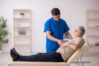 Yaşlı erkek hasta, genç doktor.