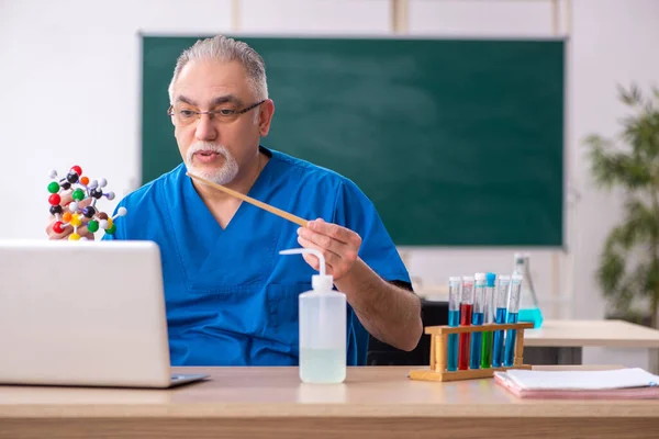 Oude mannelijke leraar scheikunde in de klas — Stockfoto