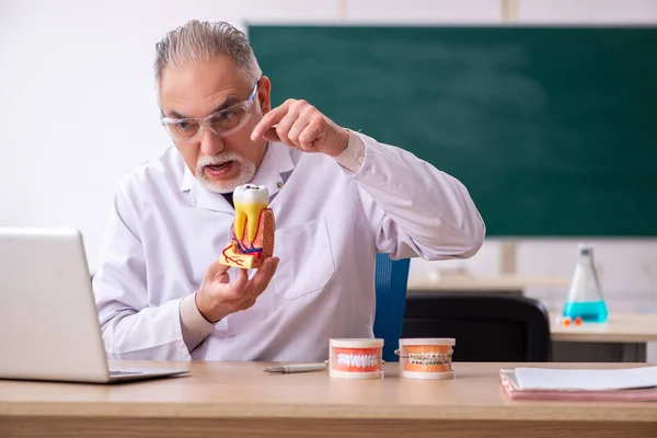 Velho médico dentista masculino em conceito telestudando — Fotografia de Stock