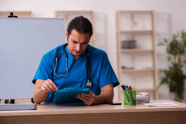 Ung manlig läkare som arbetar på kliniken — Stockfoto