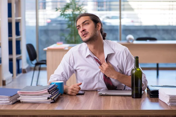 Młody mężczyzna uzależniony od alkoholu pracownik pracujący w biurze — Zdjęcie stockowe