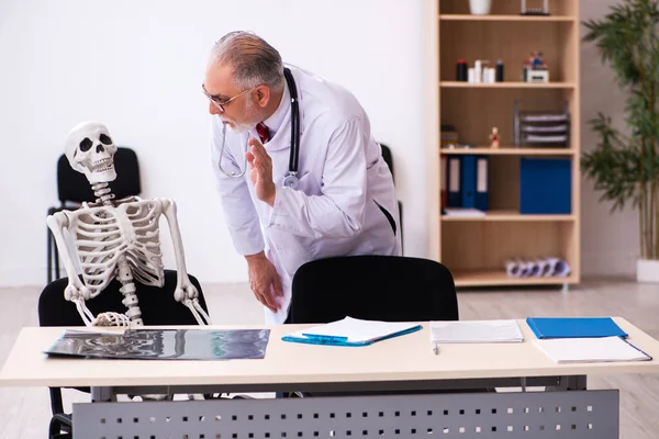 Anciano médico y paciente esqueleto en la clínica — Foto de Stock