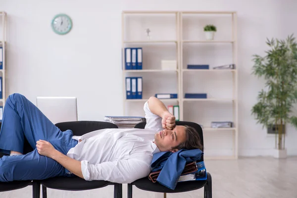 Young male employee sleeping in the office on chairs — Stock Photo, Image