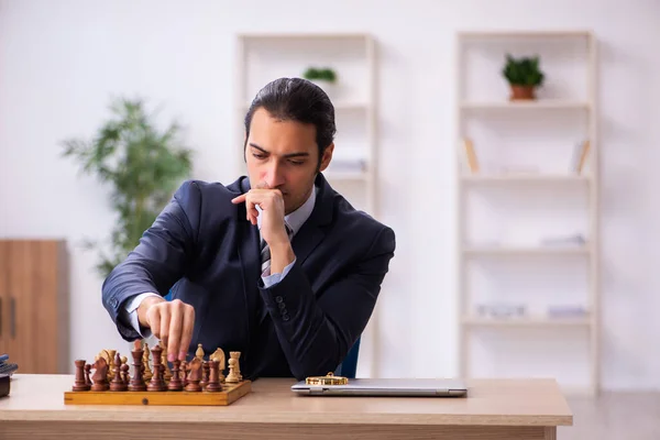 Young male employee playing chess at workplace — Stock Photo, Image