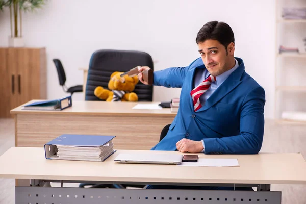 Joven empleado masculino y su juguete oso jefe en concepto divertido — Foto de Stock