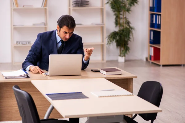 Jovem empregador do sexo masculino sentado no escritório — Fotografia de Stock