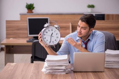 Ofisteki aşırı işten memnun olmayan genç bir erkek işçi.