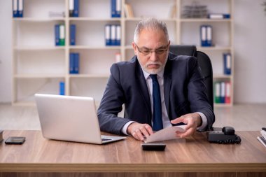 Ofiste çalışan yaşlı bir erkek.