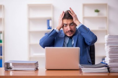 Genç işadamı ve ofiste çok fazla iş var.