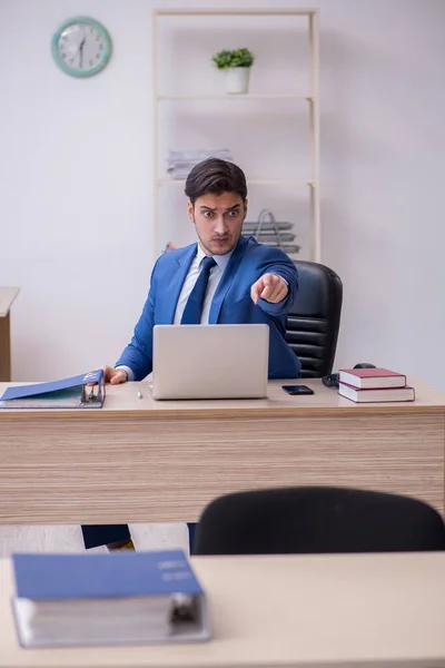 Jonge mannelijke werknemer ongelukkig met buitensporig werk — Stockfoto