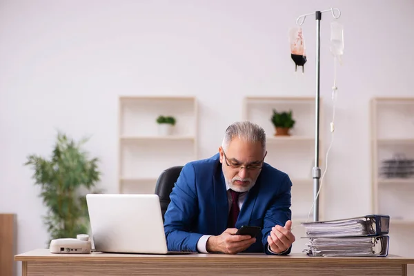 Oude mannelijke werknemer in het concept bloedtransfusie — Stockfoto