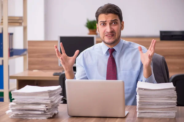 Joven empleado masculino descontento con el trabajo excesivo en la oficina — Foto de Stock